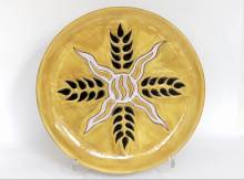 Jean LURCAT. Plat rond en céramique à décor d'épi sur fond moutarde